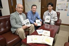 町民文芸誌「浚渫」の５０号を手にする（左から）佐藤さん、小田さん、町教委社会教育課の小柳雄貴さん。手前は過去に発刊した文芸誌