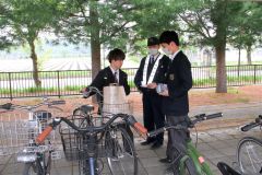 自転車通学の本別高校生に、安全利用を呼び掛ける同校ボランティア部の部員と本別署員
