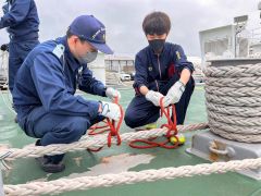 海保職員からロープワークを学ぶ高桑さん（右）
