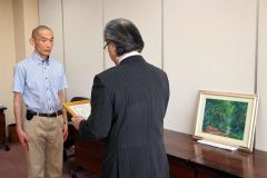 田中学長（右）から水彩画を寄贈した紺野さん（左）に感謝状を贈った