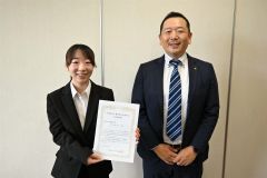 川田会長（右）から奨学生決定通知書を受けた村井さん（左）
