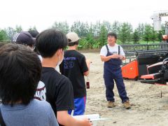 中学生にスマート農業について説明する岡田さん（右）