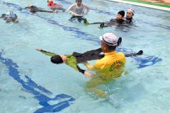 佐藤さん（手前）に水中で浮くコツを教わる児童