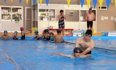 アジア大会金メダリストの坂田選手から指導を受ける本別水泳少年団の子どもたち