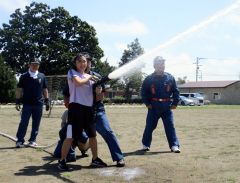 消防団員の指導で放水を体験する児童