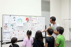 子どもたちが作った葉っぱアートを参加者らと鑑賞する小寺さん（右）