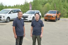 新型トライトン（右奥）を紹介する加藤社長（右）と第一車両技術開発本部の増岡浩担当部長