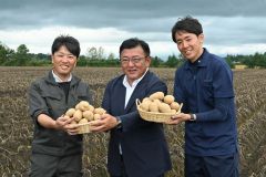 ジャガイモを手に笑顔を見せる（左から）郷原組合長、田崎社長、岡村支所長