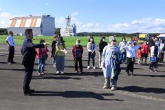 黒川町長（左）から宇宙関連施設の説明を受けるツアーの参加者
