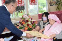 １００歳の和田さんに祝い状を手渡す安井町長（左）
