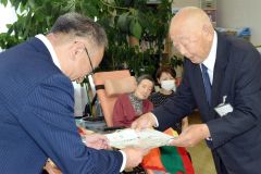 大熊理事長に米寿の祝いを手渡す安井町長（左）
