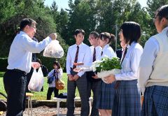 講演のお礼に生徒から山口さんへ学校で育てた野菜や花、「さらのうキーマカレー」が送られた