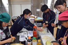 夕食を作る児童と手助けする池田高校の生徒や学習支援ボランティア