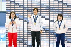 女子１５００メートル表彰でスタンドに向かって笑顔で手を振る高木美帆（中央）。左は２位の堀川桃香、右は３位の佐藤綾乃（金野和彦撮影）
