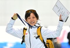 女子１５００メートルの表彰後、メダルと賞状を掲げ、関係者に笑顔を見せる高木美帆（金野和彦撮影）