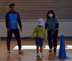 スカイアースの横山選手（左）にサッカーを教えてもらう児童