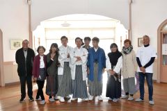羽織袴姿で記念写真を撮影した下野さん（左から４人目）、堀田理事長（同５人目）、窪田さん（右から４人目）と撮影を支えたスタッフら