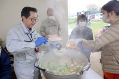 野菜がたっぷり入った豚汁をよそう町社協の石川事務局長（左）