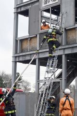 訓練棟にはしごを使って登り、救助訓練を行う署員たち