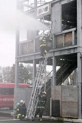 訓練棟にはしごを使って登り、救助訓練を行う署員たち