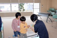 歯科衛生士の太田さん（右）からキシリトールタブレットをもらう親子