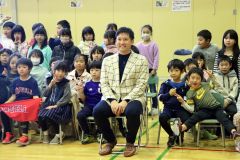 上士幌小児童と一緒に笑顔で写真撮影に参加する杉谷さん（中央）