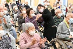 社会福祉施設の利用者らに自慢の歌声を披露する中村仁美さん（中央）