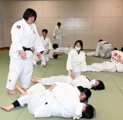 固め技を指導する塚田さん（左）