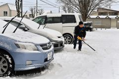 駐車場の雪を除雪する請負業者（１７日午前８時２０分ごろ、市内西１０南１９。金野和彦撮影）