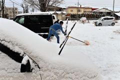 駐車場の雪を除雪する請負業者（１７日午前８時２０分ごろ、市内西１０南１９。金野和彦撮影）