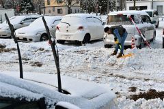 駐車場の雪を除雪する請負業者（１７日午前８時５０分ごろ、市内西１０南１９。金野和彦撮影）