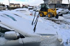 駐車場の雪を除雪する請負業者（１７日午前８時４０分ごろ、市内西１０南１９。金野和彦撮影）