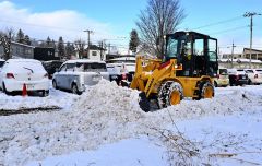 駐車場の雪を除雪する請負業者（１７日午前８時４０分ごろ、市内西１０南１９。金野和彦撮影）