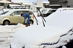 駐車場の雪を除雪する請負業者（１７日午前８時半ごろ、市内西１０南１９。金野和彦撮影）