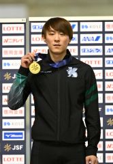 距離別男子１０００メートルで優勝し、表彰台で金メダルを掲げる野々村太陽（金野和彦撮影）
