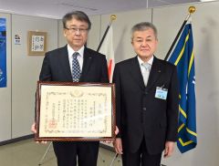 広瀬教育長から「北海道教育功績者表彰」を伝達された村松校長（左））