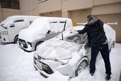車の除雪を行う運転手（２３日午前７時４５分ごろ、須貝拓也撮影）