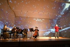 冬景色が映し出された舞台で歌声を響かせる原田さん（右）
