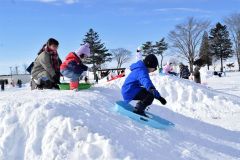 雪山でそり滑りを楽しむ子どもたち
