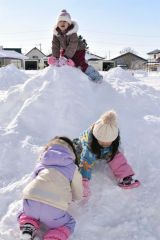 雪山でそり滑りを楽しむ子どもたち
