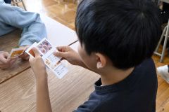 給食の写真カードを見る児童