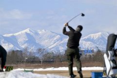 雪解けが進む練習場で、爽快にボールを飛ばすゴルファー（２３日午前１１時ごろ、札内川ゴルフ練習場で。金野和彦撮影）
