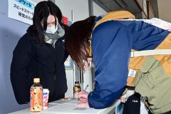 明治北海道十勝オーバルの小学生大会で保護者らにアンケートを取る石野さん（１月）