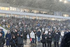 雪が降りしきる中応援する観客