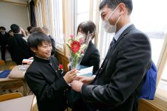 「ありがとう」―。式が終了し、同席した父母に感謝の花を手渡す卒業生（大樹小、石原秀樹通信員撮影）
