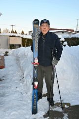 自宅前でスキーを手にする宮本さん