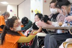 愛犬「ララ」と新得町内の障害者支援施設を訪れた丸山さん（左）