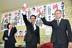 初当選を祝して、支持者らと乾杯する田中氏（中央）。左は妻朋子さん（２１日、午後９時半ごろ、広尾町内の選挙事務所で。金野和彦撮影）