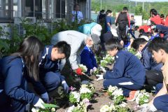 協力して花苗を植える生徒と地域住民