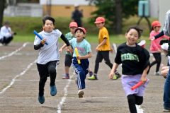 ３・４年生のリレーで力いっぱい走る子どもたち（８日、更別小学校。金野和彦撮影）